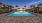 a pool with a deck and umbrellas by it